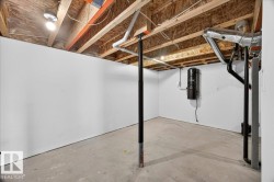 Unfinished basement space featuring exposed wood joists and subflooring, a central vacuum system, and concrete flooring - 