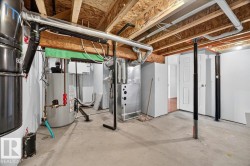 Basement utility area featuring exposed joist ceiling, concrete flooring, and white painted walls - 