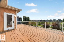 Expansive outdoor deck featuring wood-finish composite decking and a glass panel railing - 