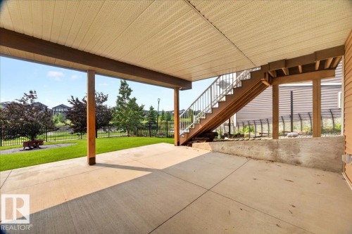 Ground-level concrete patio featuring a covered ceiling and wood support columns - 8508 218 Street, Edmonton, AB 