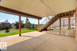 Ground-level concrete patio featuring a covered ceiling and wood support columns - 
