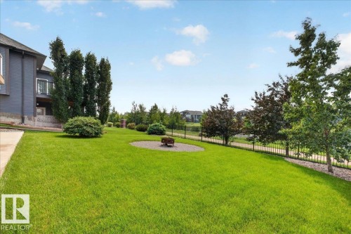 Expansive green lawn with a circular gravel fire pit area - 8508 218 Street, Edmonton, AB 