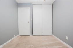 Room featuring light grey walls, light-colored carpeting, white baseboards, and a white interior door - 