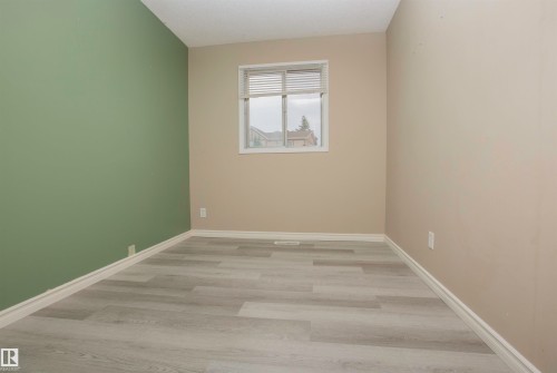 Room featuring light wood-finish flooring, a window with horizontal blinds, and a textured ceiling - 3531 46 Street, Edmonton, AB 