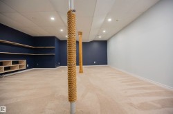 Spacious room featuring carpeting, recessed lighting, built-in shelving, a drop ceiling, and a support column - 