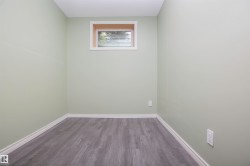 Room featuring light green walls, white trim, and wood-finish flooring - 