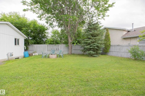 Spacious backyard featuring a manicured lawn, established trees, and a privacy fence - 3531 46 Street, Edmonton, AB 