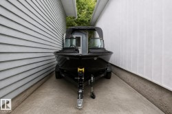 Paved concrete side yard featuring horizontal siding on one side and vertical siding on the other - 