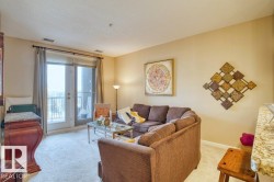 Living area featuring a double glass door balcony entrance, light-colored carpet flooring, and neutral wall tones - 