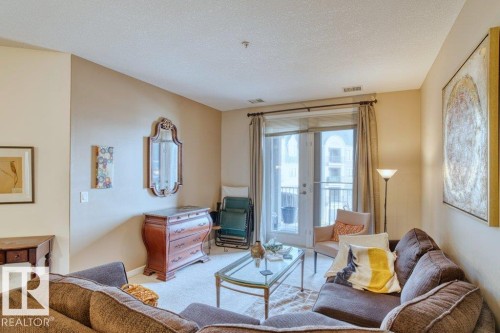 Living space featuring carpet flooring and light-toned wall paint - 319 6083 Maynard Way, Edmonton, AB 