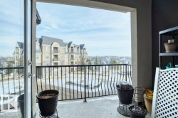 Exterior balcony featuring a concrete floor, wrought iron railing, and a glass door providing property access - 