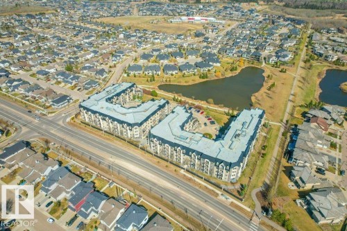 Aerial perspective showcasing a residential development with two prominent L-shaped buildings - 319 6083 Maynard Way, Edmonton, AB 