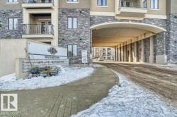 Stone facade building entrance featuring a prominent sign for "Waterstone" and a covered drive-through portico - 
