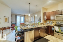 Kitchen featuring dark wood-finish cabinetry, stainless steel appliances, and granite countertops - 