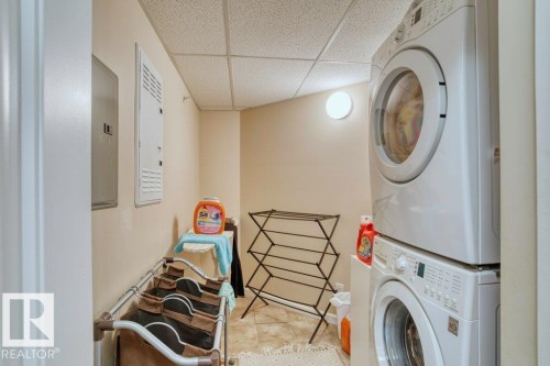 Dedicated laundry area featuring stacked appliances and tiled flooring - 319 6083 Maynard Way, Edmonton, AB 
