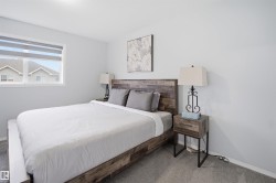Carpeted bedroom with a window featuring horizontal blinds - 