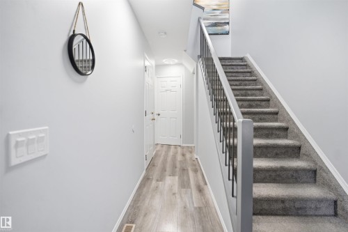 Carpeted staircase with contemporary metal balusters and a painted handrail - 92 230 Edwards Drive, Edmonton, AB 