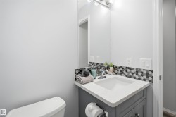 Modern vanity featuring a white countertop with integrated sink, chrome faucet, and gray cabinetry - 