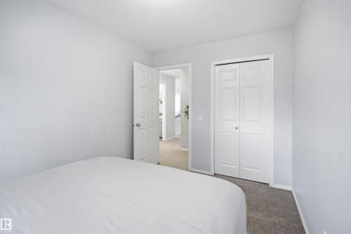 Bedroom featuring light gray walls, white trim, and gray carpeting - 92 230 Edwards Drive, Edmonton, AB 