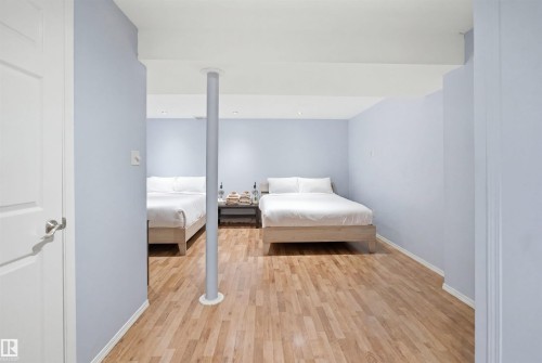 Spacious interior room featuring wood-finish flooring, light blue walls, and recessed lighting - 92 230 Edwards Drive, Edmonton, AB 
