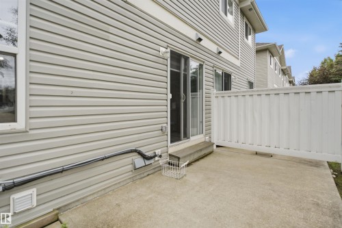 Concrete patio featuring a privacy fence and sliding glass door access - 92 230 Edwards Drive, Edmonton, AB 