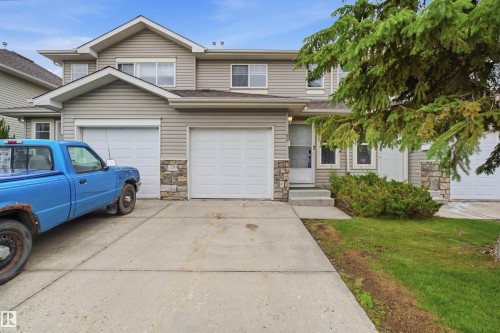 Two-story residence featuring light-colored siding and stone accents - 92 230 Edwards Drive, Edmonton, AB 
