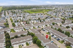 Aerial perspective showcasing a residential community with townhomes and single-family residences - 