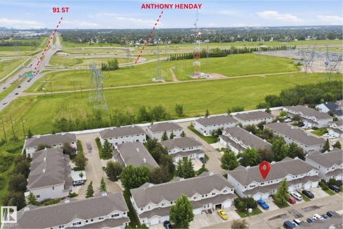 Townhouse property featuring a light-colored exterior, an attached garage, and a peaked roof - 92 230 Edwards Drive, Edmonton, AB 