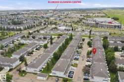 Aerial perspective of a multi-unit residential development with light-colored siding and dark-pitched roofs - 