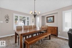 Dining area featuring large window with blinds, recessed wall niche, and durable tile flooring - 