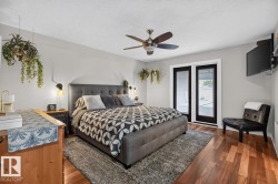 Bedroom featuring wood-finish flooring, a ceiling fan with integrated lighting, and a neutral color palette - 