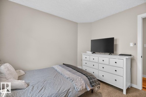 Carpeted room with neutral wall tones and a textured ceiling - 448 Ormsby Road W, Edmonton, AB 