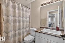 Bathroom featuring a white vanity with an integrated sink, a dark countertop, and a chrome faucet - 