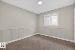 Room featuring neutral painted walls, wainscoting, and carpet flooring - 