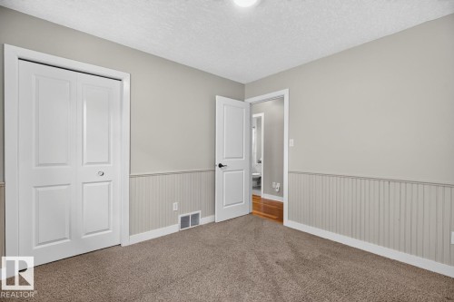 Wall-to-wall carpeting with light gray walls and white wainscoting - 448 Ormsby Road W, Edmonton, AB 