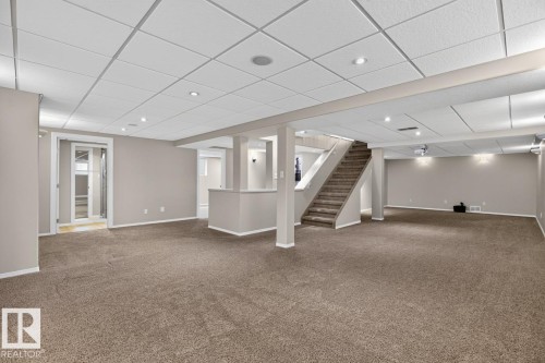 Expansive lower-level space featuring broadloom carpet, recessed lighting, and a drop ceiling - 448 Ormsby Road W, Edmonton, AB 