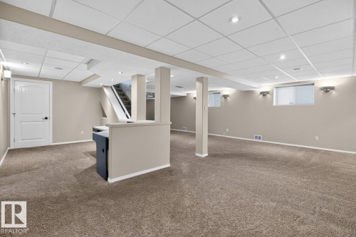 Expansive lower level featuring neutral carpeting, recessed lighting, drop ceiling, white trim, and light-colored walls - 448 Ormsby Road W, Edmonton, AB 