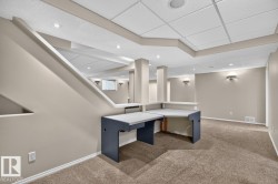 Finished lower level featuring neutral wall tones, recessed lighting, and a built-in desk area - 