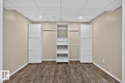 Room featuring wood-finish flooring, neutral wall paint, and a drop ceiling with recessed lighting - 