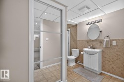 Bathroom featuring a contemporary vanity with an integrated sink, ceramic tile flooring, and wainscoting - 