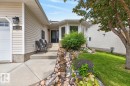 Front exterior featuring beige horizontal siding and a dark blue entry door - 448 Ormsby Road W, Edmonton, AB 