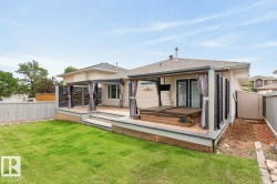 Expansive backyard featuring a multi-level deck, a built-in spa, and a covered patio area with privacy screens - 
