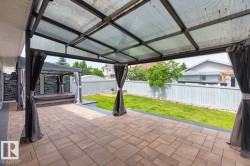 Expansive outdoor deck with pavers and a covered structure - 
