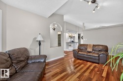 Hardwood-style flooring throughout, with neutral wall paint and a textured ceiling - 
