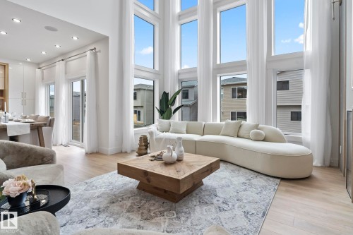 Two-story living area featuring extensive window treatments, recessed lighting, light wood-finish flooring, and a sliding glass door to the exterior - 13152 187 Avenue, Edmonton, AB 