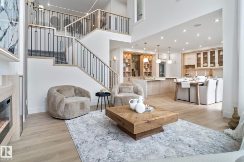Open-concept living area with high ceilings, wood-finish flooring, and a modern fireplace feature - 13152 187 Avenue, Edmonton, AB 