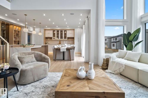 Open-concept living space featuring wood-finish flooring, recessed lighting, and expansive windows - 13152 187 Avenue, Edmonton, AB 
