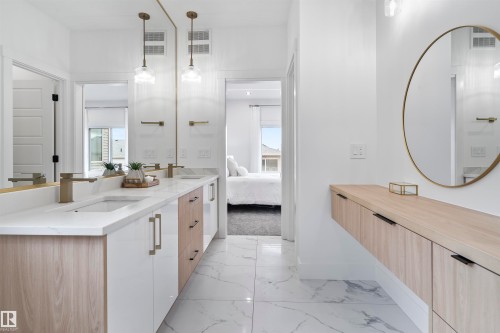 Dual vanity featuring light wood-finish and white cabinetry with brushed gold hardware - 13152 187 Avenue, Edmonton, AB 