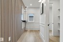 Hallway featuring a slatted wood-panel accent wall, wainscoting, wood-finish flooring, and recessed lighting - 13152 187 Avenue, Edmonton, AB 