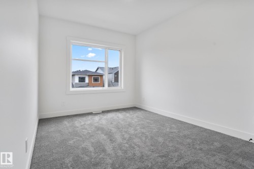 Bright room featuring a large window, plush gray carpeting, and white baseboards - 13152 187 Avenue, Edmonton, AB 